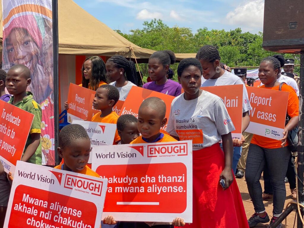 Children holding placards with messages against GBV during the launch of the 16 days of Activism at Mazengera Primary School(Photo by Girls 4 Change)
